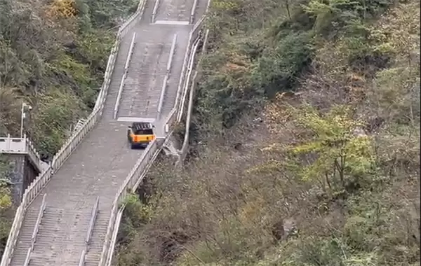 尴尬!一电动车挑战爬天门山台阶失败:溜车后撞坏护栏