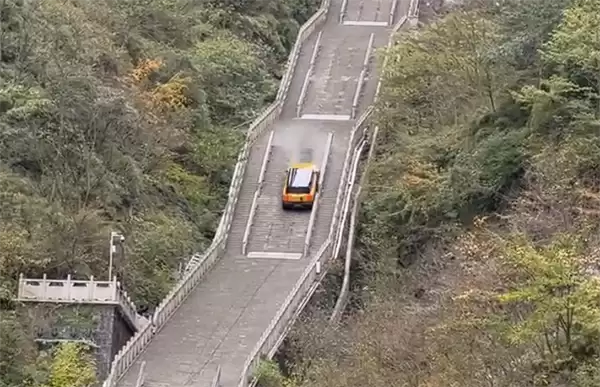 尴尬!一电动车挑战爬天门山台阶失败:溜车后撞坏护栏