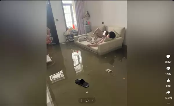 暴雨淹了家:夫妻俩1个玩手机1个补觉 太淡定了